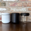 Tre vakuumbeholdere til kaffe i hvid, sort og transparent design for optimal opbevaring.
