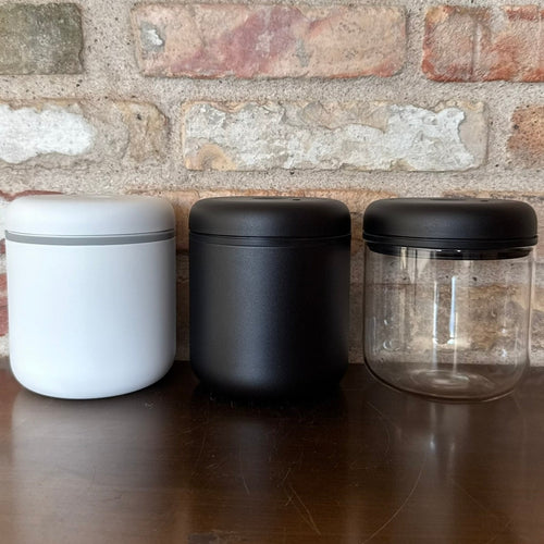 Tre vakuumbeholdere til kaffe i hvid, sort og transparent design for optimal opbevaring.