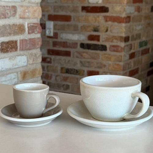 Keramik kaffekopper og krus i forskellige størrelser på et bord.

