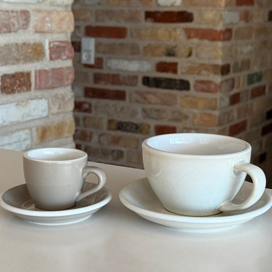 Keramik kaffekopper og krus i forskellige størrelser på et bord.

