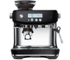 Sage espressomaskine i sort og stål med kaffebønner og portafilter.


